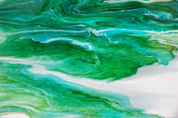 Abstract image with swirling patterns of green, teal, and white resembling marbled paint or flowing water. The fluid shapes blend smoothly, creating a vibrant and dynamic visual effect.